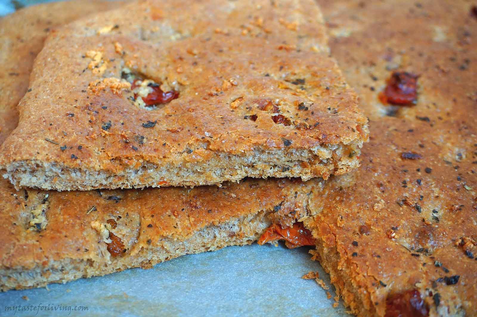 Delicious and appetizing whole wheat focaccia with sun dried tomatoes in olive oil, basil and garlic.