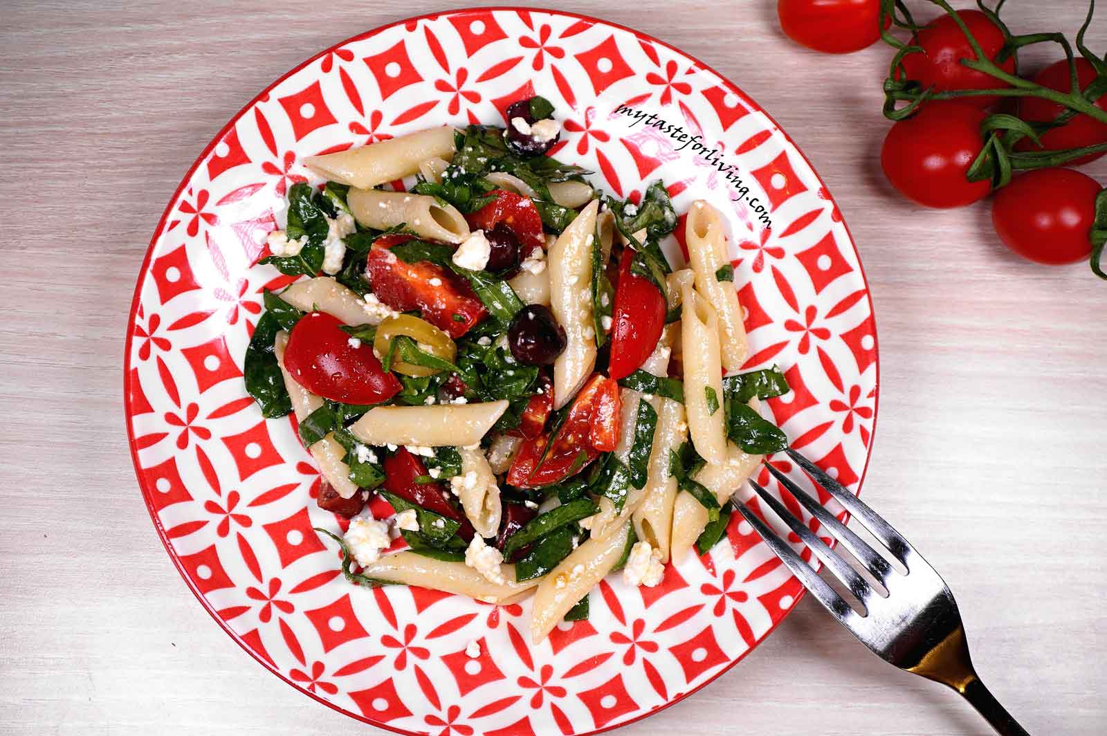 Easy, tasty and satisfying fresh salad of fresh spinach, combined with pasta, cherry tomatoes and olives, sprinkled with feta cheese, which can easily be used as a main dish.